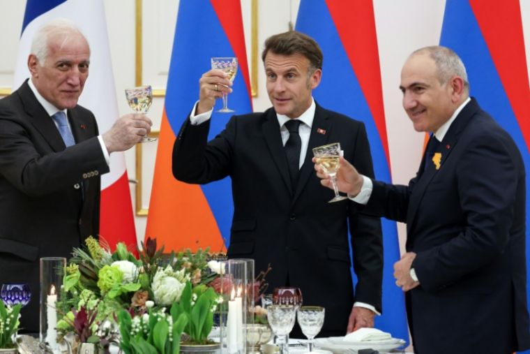 Armenia's President Vahagn Khachaturyan, France's President Emmanuel Macron and Armenia's Prime Minister Nikol Pashinyan share a toast during a state dinner in the honour of the French leader at the presidential palace in Yerevan on May 4, 2026. ( AFP / Ludovic MARIN )
