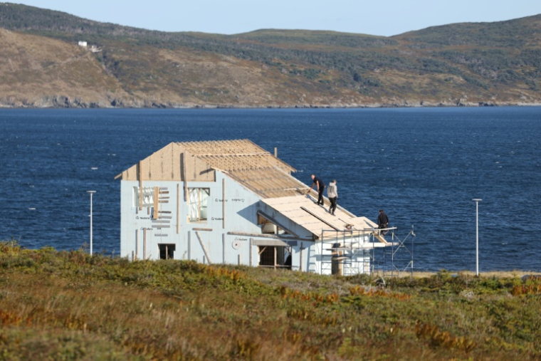 Des ouvriers participent à la construction de la toiture d'une maison dans le nouveau village de Miquelon, sur l'archipel de Saint-Pierre-et-Miquelon, le 20 septembre 2026 ( AFP / Ludovic MARIN )