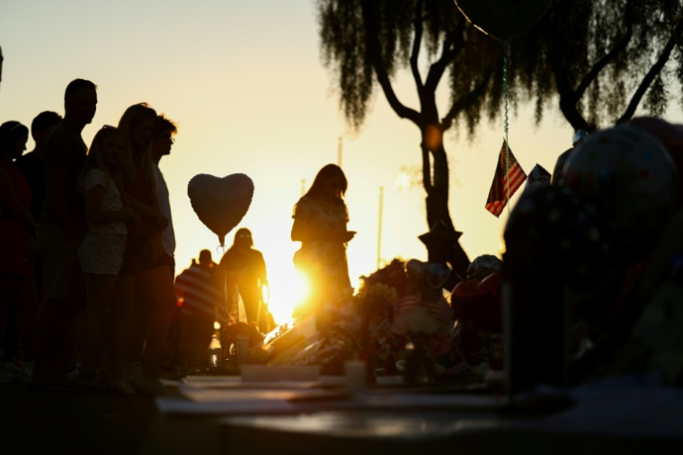 Des personnes se recueillent devant un mémorial improvisé en hommage à l'influenceur conservateur Charlie Kirk à Phoenix, en Arizona, le 14 septembre 2025 ( AFP / CHARLY TRIBALLEAU )