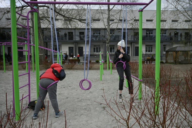 Des enfants jouent devant un bâtiment rénové pour accueillir des déplacés de guerre, le 25 avril 2026 à Slavoutytch dans le nord de l'Ukraine ( AFP / Genya SAVILOV )