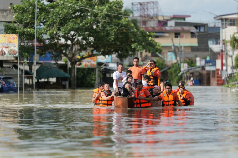 Des secouristes évacuent des habitants en bateau à Tuguegarao, au nord de Manille, alors que les eaux de crue continuent d'inonder les maisons en raison des fortes pluies provoquées par le super typhon Fung-wong, le 11 novembre 2025 aux Philippines ( AFP / John Dimain )