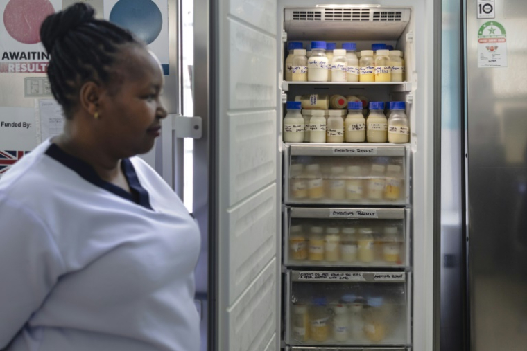 Une infirmière se tient à côté d'une vitrine réfrigérée contenant des bouteilles de lait maternel provenant de donations faites à la banque de lait de la maternité de l'hôpital Pumwani à Nairobi, le 4 septembre 2025 ( AFP / Tony KARUMBA )