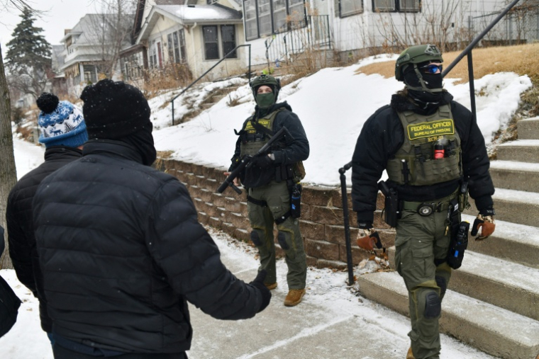 Des agents fédéraux face à des civils le 16 janvier 2026 à Saint Paul, dans le Minnesota ( AFP / Octavio JONES )
