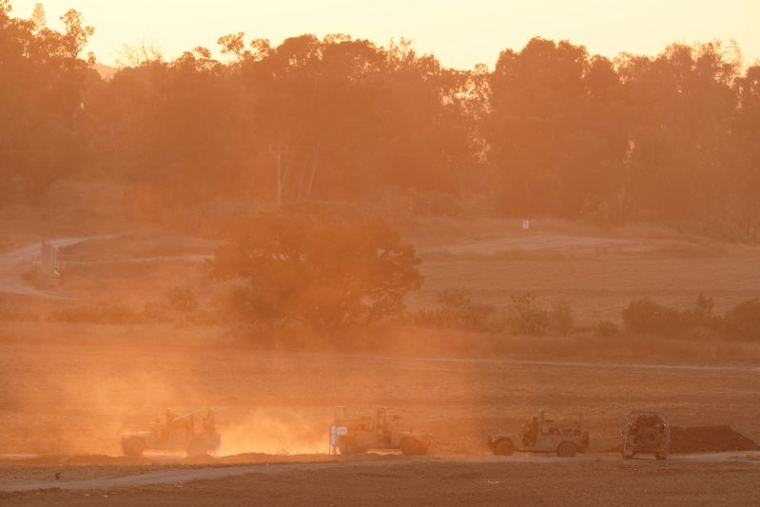 Des véhicules militaires israéliens manœuvrent près de la frontière entre Gaza et Israël, en Israël