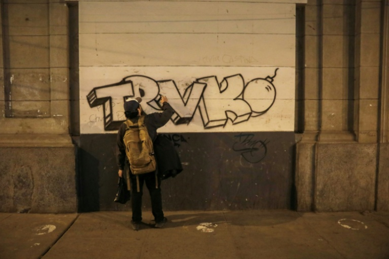 Un homme peint un graffiti avec le mot "Trvko", le surnom du manifestant assassiné Eduardo Ruiz, lors d'une manifestation contre le président par intérim du Pérou, José Jeri, à Lima, le 16 octobre 2025 ( AFP / CONNIE FRANCE )