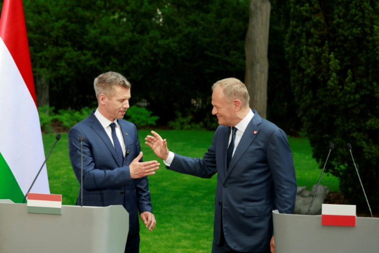Le Premier ministre hongrois Peter Magyar (G) et son homologue polonais Donald Tusk lors d'une conférence de presse à Varsovie le 20 mai 2026 ( AFP / Wojtek RADWANSKI )