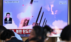 Des personnes sont assises près d'un écran TV diffusant un bulletin d'information avec des images d'archives d'un essai de missile nord-coréen, le 20 septembre 2026 dans une gare de Séoul ( AFP / Lillian SUWANRUMPHA )