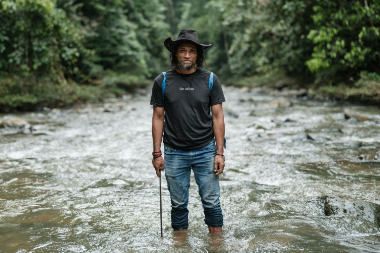 Bokum, membre de la tribu des Hongana Manyawa ("Peuple de la forêt"), au milieu d'une rivière qui, selon les habitants, a été polluée par l'exploitation minière de nickel à East Halmahera, dans le nord des Moluques, le 16 avril 2025 en Indonésie ( AFP / YASUYOSHI CHIBA )