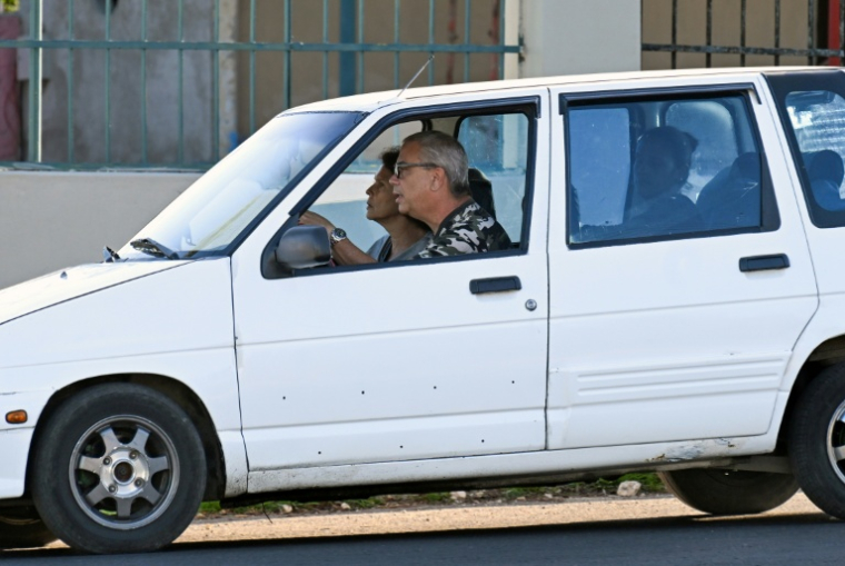 Gina Maria Gonzalez Garcia (à g.), épouse de l’ancien ministre cubain de l'Économie Alejandro Gil, et leur fille Laura Maria Gil (à dr.) arrivent au tribunal municipal populaire de Marianao, à La Havane, le 26 novembre 2025, où se tient le procès de l'ancien ministre ( AFP / YAMIL LAGE )