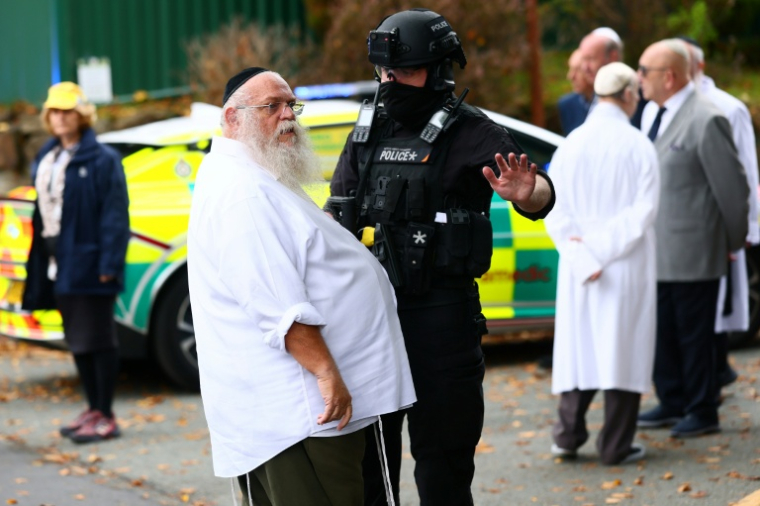 Un policier parle avec un membre de la communauté juive de Manchester (Royaume-Uni) après une attaque meurtrière contre une synagogue, le 2 octobre 2025 ( AFP / Paul Currie )