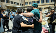 Un membre du personnel médical et d'autres hommes se tiennent parmi les corps de victimes des récents affrontements entre des combattants druzes et des tribus bédouines, disposés pour identification dans la cour d'un hôpital dans la ville de Soueida, dans le sud de la Syrie, le 17 juillet 2025 ( AFP / Shadi AL-DUBAISI )