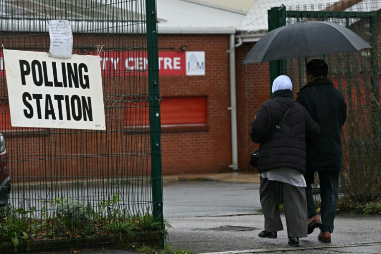 Des électeurs se rendent au bureau de vote à Levenshulme, dans le Grand Manchester, pour la législative partielle de Gorton et Denton, le 26 février 2026 ( AFP / Paul ELLIS )