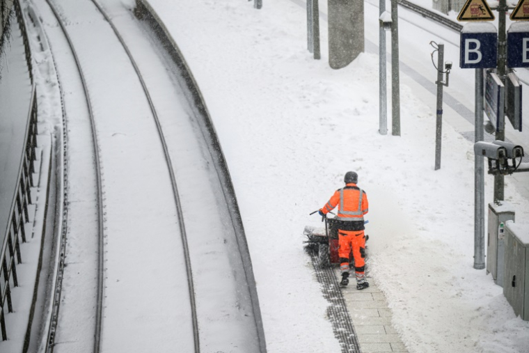Un employé déblaye la neige d'un quai de la gare centrale de Hambourg, dans le nord de l'Allemagne, le 9 janvier 2026 ( AFP / DANIEL REINHARDT )