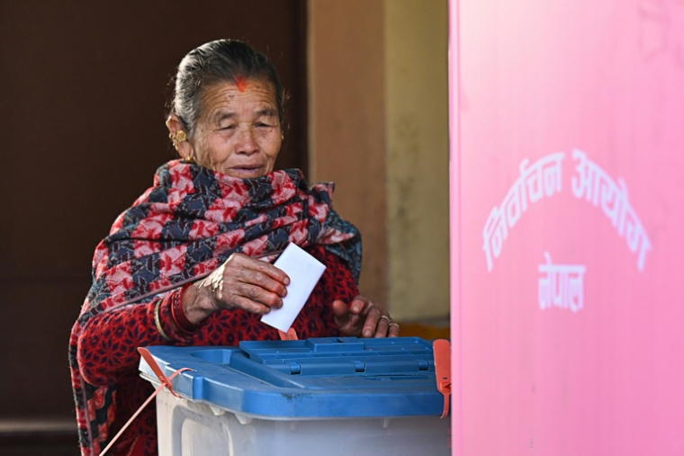 Une femme dépose son bulletin dans l'urne dans un bureau de vote lors des élections législatives népalaises à Katmandou, le 5 mars 2026 ( AFP / Prakash Mathema )