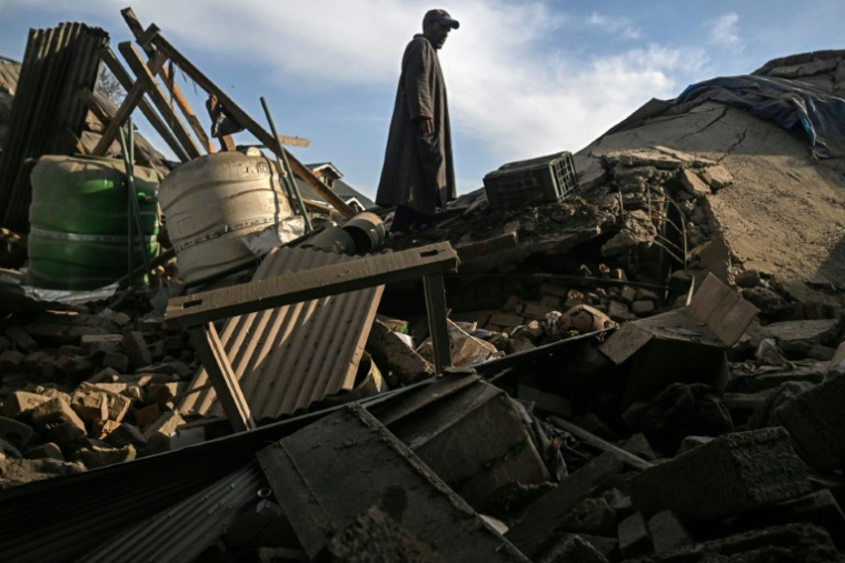 Un homme dans les décombres d'une maison appartenant à une famille soupçonnée d'être impliquée dans l'attaque des touristes de Pahalgam, dans le village de Murran à Pulwama, au sud de Srinagar, le 26 avril 2025 en Inde ( AFP / Tauseef MUSTAFA )