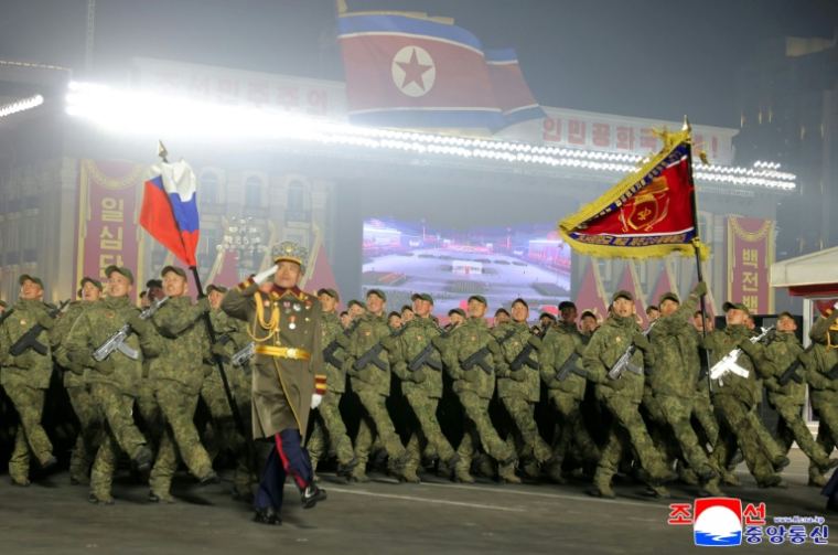 Photo prise le 25 février 2026 et diffusée le 26 février 2026 par l'agence de presse officielle nord-coréenne KCNA, montrant des soldats envoyés en Russie défilant sous le drapeau russe lors des commémorations du 9e Congrès du Parti des travailleurs de Corée, place Kim Il-sung à Pyongyang ( KCNA VIA KNS / STR )