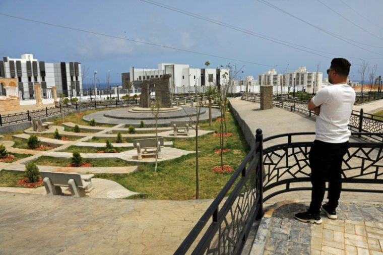 Un homme observe le nouveau projet de logements en construction dans le quartier d'Al-Salam à Derna, le 17 mai 2026, dans le cadre du plan de reconstruction de la ville, près de trois ans après le passage dévastateur d'une tempête qui a fait près de 4 000 victimes ( AFP / Abdullah DOMA )