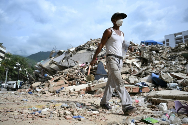 Un homme marche parmi les ruines d'immeubles effondrés à Caraballeda, dans l'Etat de La Guaira, au Venezuela, le 8 juillet 2026, à la suite du puissant double séisme ( AFP / Raul ARBOLEDA )