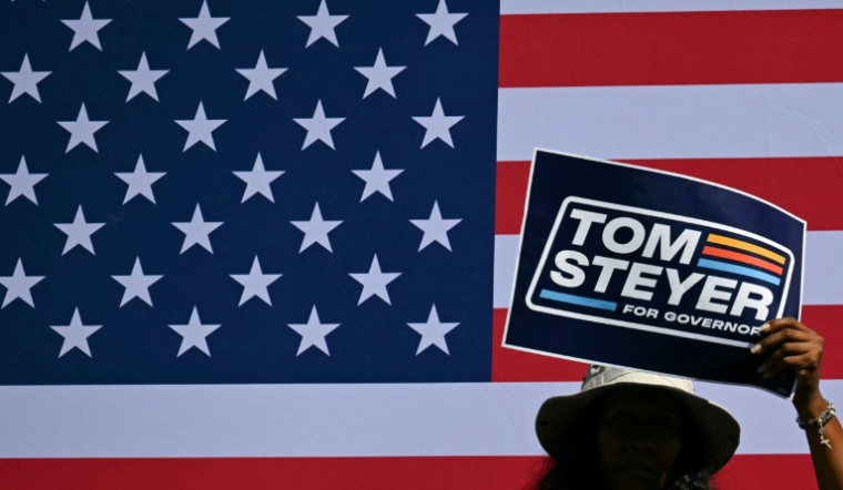 Des supporters de Tom Steyer, candidat démocrate à l’élection du gouverneur de Californie, brandissent des écriteaux le soutenant pendant l’un de ses discours de campagne à Los Angeles, le 31 mai 2026 ( AFP / Patrick T. Fallon )