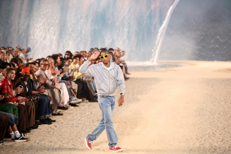 Le rappeur et créateur de mode américain Pharrell Williams salue le public après avoir présenté les créations du défilé de la collection homme printemps-été 2027 de Louis Vuitton, dans le cadre de la Fashion Week de Paris, le 23 juin 2026 ( AFP / SIMON WOHLFAHRT )