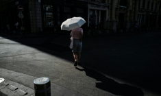 Une passante s'abrite sous une ombrelle pour se protéger du soleil à Lyon lors d'un épisode de canicule, le 24 juin 2026 ( AFP / OLIVIER CHASSIGNOLE )
