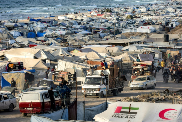 Des véhicules passent devant des tentes dressées le long du front de mer de la ville de Gaza, dans le nord de la bande de Gaza, alors des habitants fuient vers le sud, le 2 septembre 2025 ( AFP / Eyad BABA )