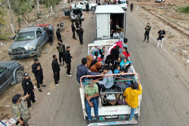 Vue aérienne d'un camion transportant des membres de la communauté bédouine en cours d'évacuation stoppé à un point de contrôle installé par les forces gouvernementales syriennes le long d'une route à Taarah, dans la province de Soueida, au sud de la Syrie, en direction de Deraa, le 21 juillet 2025 ( AFP / Rami al SAYED )
