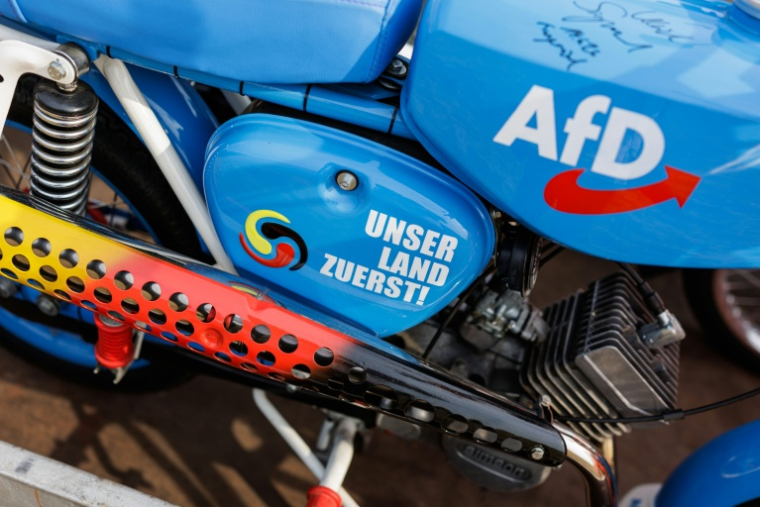 Un cyclomoteur Simson aux couleurs de l'AfD avec le slogan "notre pays d'abord", lors d'un rassemblement de campagne du candidant de l'AfD aux élections régionales de Saxe-Anhalt, Ulrich Siegmund, à Jessnitz, le 28 juin   2026 dans l'est de l'Allemagne ( AFP / Jens SCHLÜTER )