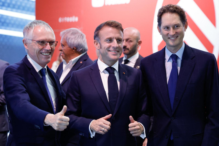 Emmanuel Macron avec John Elkann (d) et Carlos Tavares (g) au Salon de l'automobie le 14 Octobre 2024. ( POOL/AFP / LUDOVIC MARIN )
