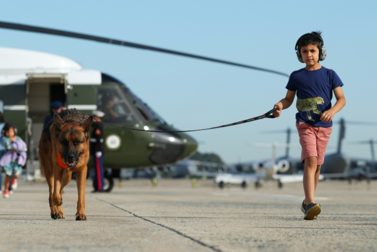 Vivek Vance (D), fils de JD Vance, court avec son chien Atlas, avant d'embarquer à bord d'Air Force Two dans le Maryland le 9 octobre 2026  ( POOL / Samuel Corum )