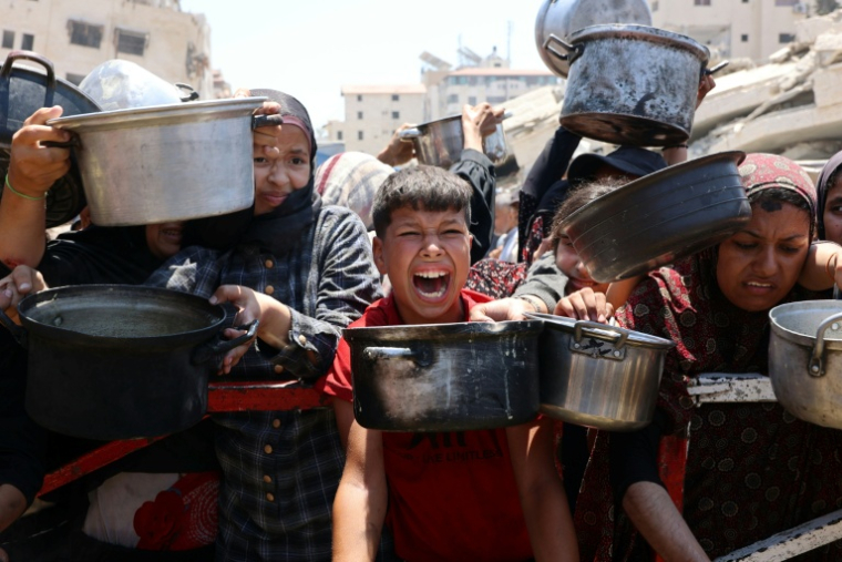 Des Palestiniens se pressent lors d'une distribution de soupe aux lentilles, à Gaza-ville le 27 juillet 2025 ( AFP / Omar AL-QATTAA )