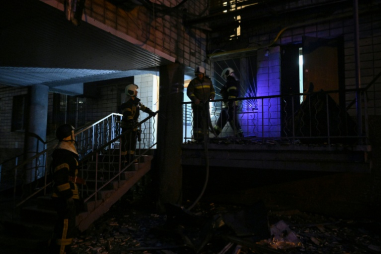 Des pompiers ukrainiens dans un immeuble résidentiel endommagé par des frappes massives de drones et de missiles russesà Kiev, le 10 octobre 2025 ( AFP / Genya SAVILOV )
