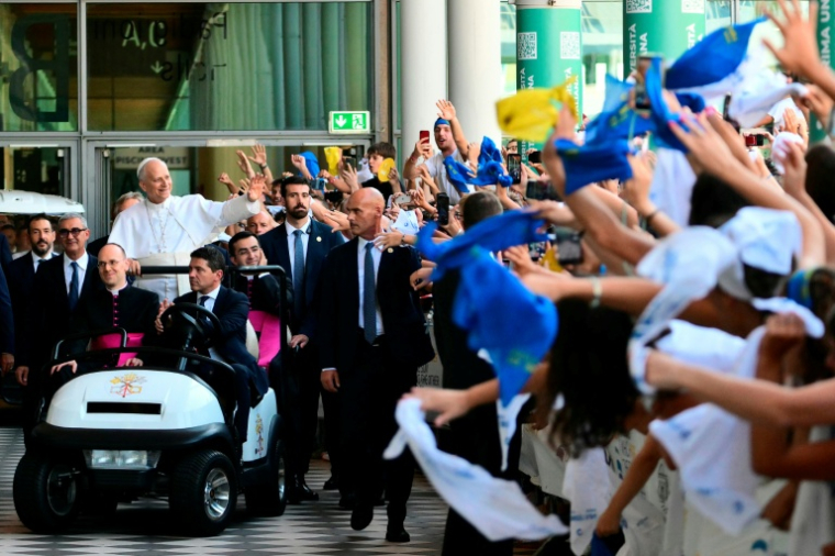 Pope Leo XIV greets the crowd as he arrives for a visit at the Children's village of the Meeting for Friendship among Peoples, the traditional gathering organised by Communion and Liberation, during a pastoral visit in Rimini on August 22, 2026. ( AFP / Stefano RELLANDINI )