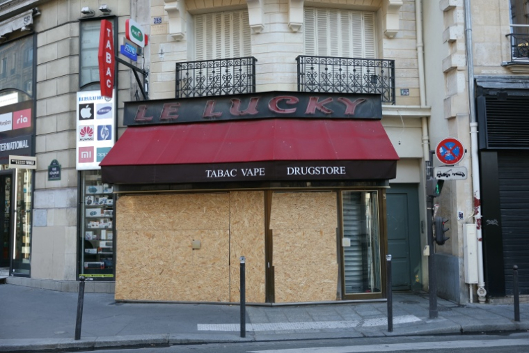 Un tabac protégé par des panneaux de bois à Paris le 30 octobre 2026 ( AFP / Thomas SAMSON )