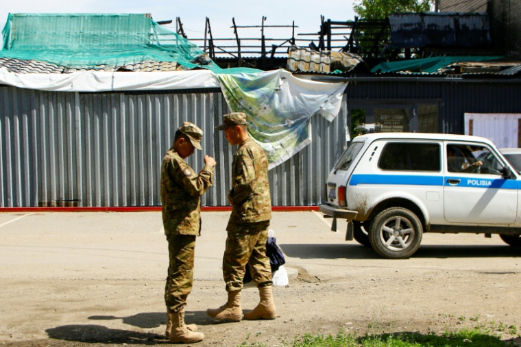 Des soldats devant le bâtiment calciné d'un restaurant après une explosion de gaz survenue en février, le 27 mai 2026 à Chtchoutchinsk, au Kazakhstan ( AFP / Ruslan PRYANIKOV )