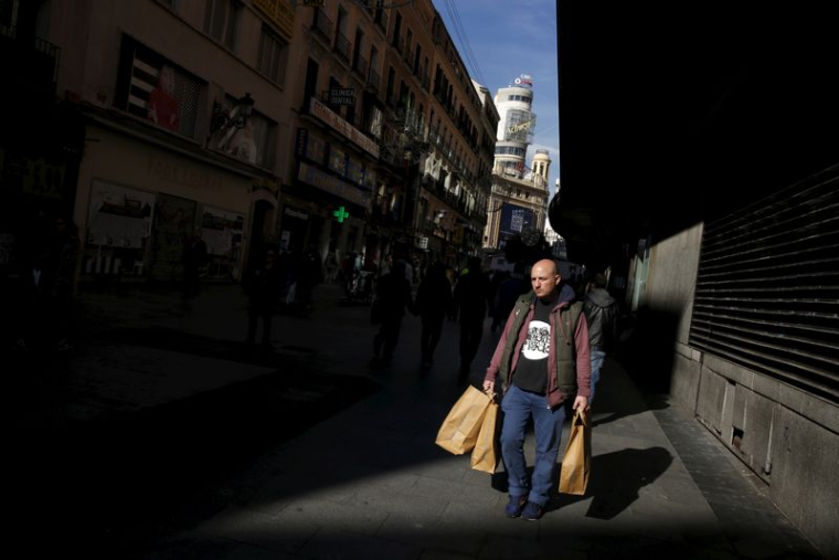 Un homme porte des sacs dans un quartier commerçant du centre-ville de Madrid