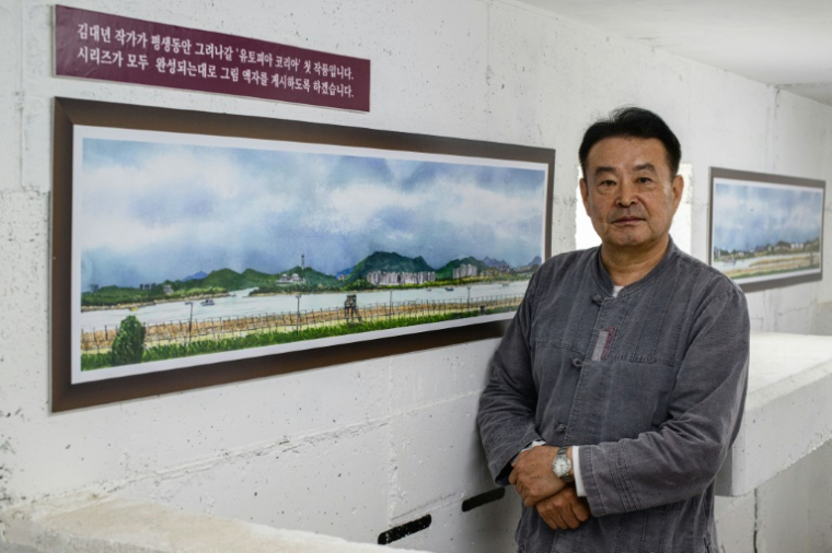L'artiste sud-coréen Kim Dae-nyeon, alias Danny Kim, devant l'un de ses tableaux, à l'intérieur d'un bunker où il expose ses œuvres, dans l'enceinte du café Daonsoop, situé à moins de deux kilomètres de la frontière nord-coréenne à Paju, au nord de Séoul, le 24 avril 2025 ( AFP / ANTHONY WALLACE )