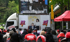 Des partisans de l'ancien président sud-coréen Yoon Suk Yeol et de son épouse Kim Keon Hee regardent la retransmission en direct du procès de l'ancienne première dame dans une rue près de la Cour d'appel de Séoul, le 28 avril 2026 ( AFP / Jung Yeon-je )