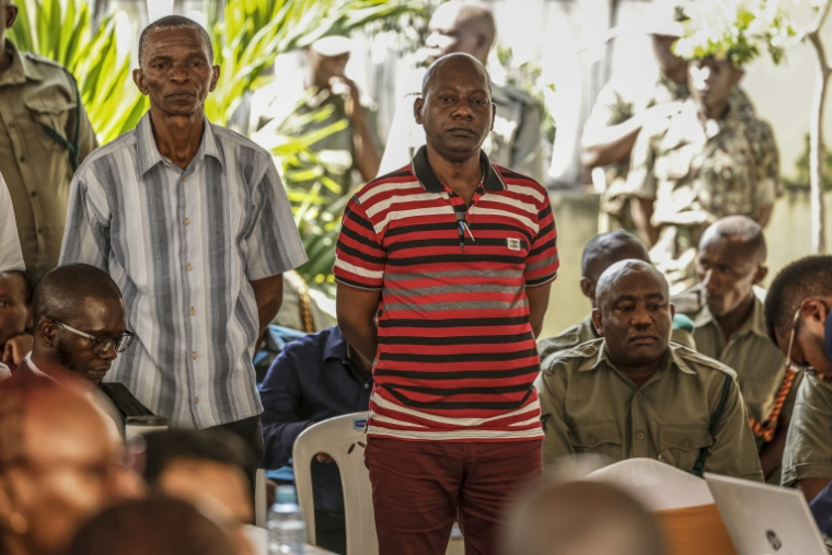 Le pasteur autoproclamé Paul Mackenzie (au centre), chef d'une secte mortifère, et ses coaccusés se tiennent debout lors de leur comparution devant le tribunal de Mombasa (Kenya), le 19 octobre 2026 ( AFP / SIMON MAINA )