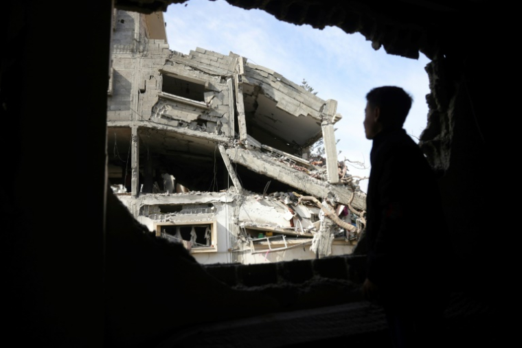 Un jeune Palestinien regarde à travers une ouverture d'un bâtiment détruit les décombres après des frappes israéliennes à Jabalia, dans le nord de la bande de Gaza, le 16 avril 2025 ( AFP / BASHAR TALEB )