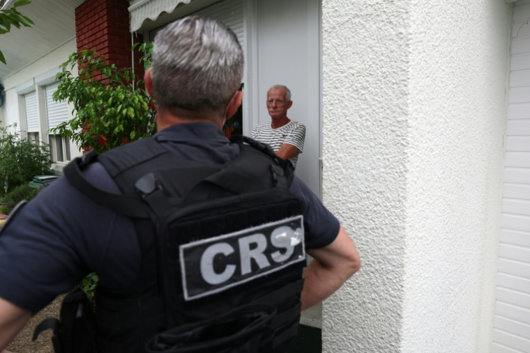 Un CRS discute avec un habitant de la commune de Saint-Médard-en-Jalles, près de Bordeaux, où un ordre d'évacuation a été émis en raison des feux de forêts, le 25 juillet 2026  ( AFP / ROMAIN PERROCHEAU )