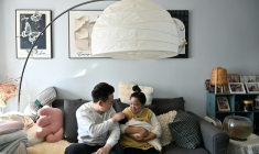 Zhang Xiaofei, 32 ans, et son époux Zhu Yunfei, 36 ans, avec leur fille de trois semaines dans leur appartement de Langfang, en périphérie de Pékin, le 6 mars 2026 ( AFP / Adek BERRY )