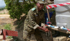 Un soldat des Forces armées de la République démocratique du Congo (FARDC) se lave les mains à l'entrée de l'aéroport de Bunia (RDC), alors qu'une épidémie d'Ebola est en cours dans la région, le 21 mai 2026 ( AFP / Seros MUYISA )