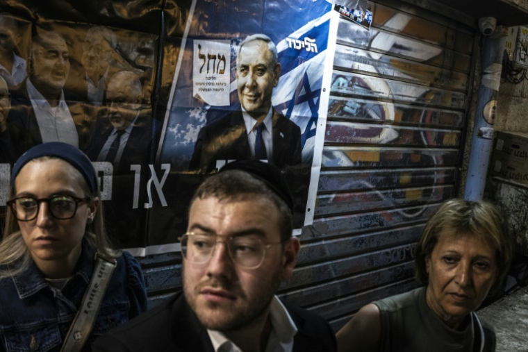 Des partisans du Premier ministre israélien Benjamin Netanyahu devant une affiche le soutenant, le 22 octobre 2026 à Jérusalem ( AFP / JOHN WESSELS )