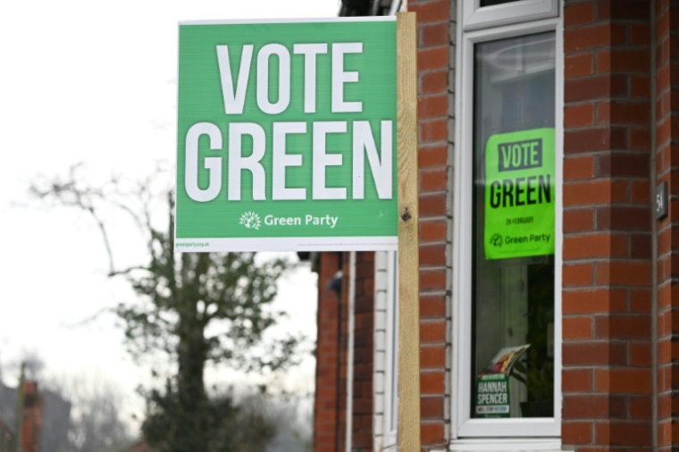 Une affiche du Parti vert est visible à la fenêtre d'une maison à Denton, dans le Grand Manchester, au nord-ouest de l’Angleterre, le 25 février 2026, à la veille d'une élection législative partielle de Gorton et Denton âprement disputée. ( AFP / Paul ELLIS )