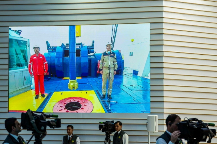 Des journalistes devant un écran diffusant la cérémonie de lancement de la quatrième phase de développement du champ gazier de Galkynysh, dans le désert du Karakoum, à l'est d'Achgabat, le 17 avril 2026 au Turkménistan ( AFP / STRINGER )