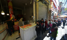 Des habitants font la queue pour acheter du poulet sur un marché touché par les pénuries dues aux barrages routiers et aux manifestations contre le président Rodrigo Paz, le 19 mai 2026 à La Paz, en Bolivie ( AFP / Aizar RALDES )
