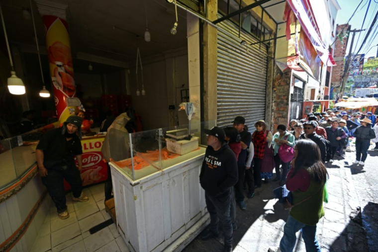 Des habitants font la queue pour acheter du poulet sur un marché touché par les pénuries dues aux barrages routiers et aux manifestations contre le président Rodrigo Paz, le 19 mai 2026 à La Paz, en Bolivie ( AFP / Aizar RALDES )