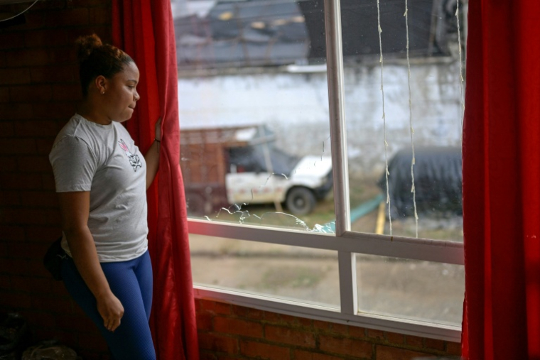 La gérante d'un hôtel, Tania Cervantes, regarde à travers une fenêtre brisée de son hôtel, à Suarez, dans le département du Cauca, en Colombie, le 27 mai 2026 ( AFP / Joaquín SARMIENTO )