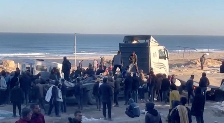Des Palestiniens transportent des blessés à la suite de tirs israéliens sur des personnes attendant de l'aide, dans la ville de Gaza